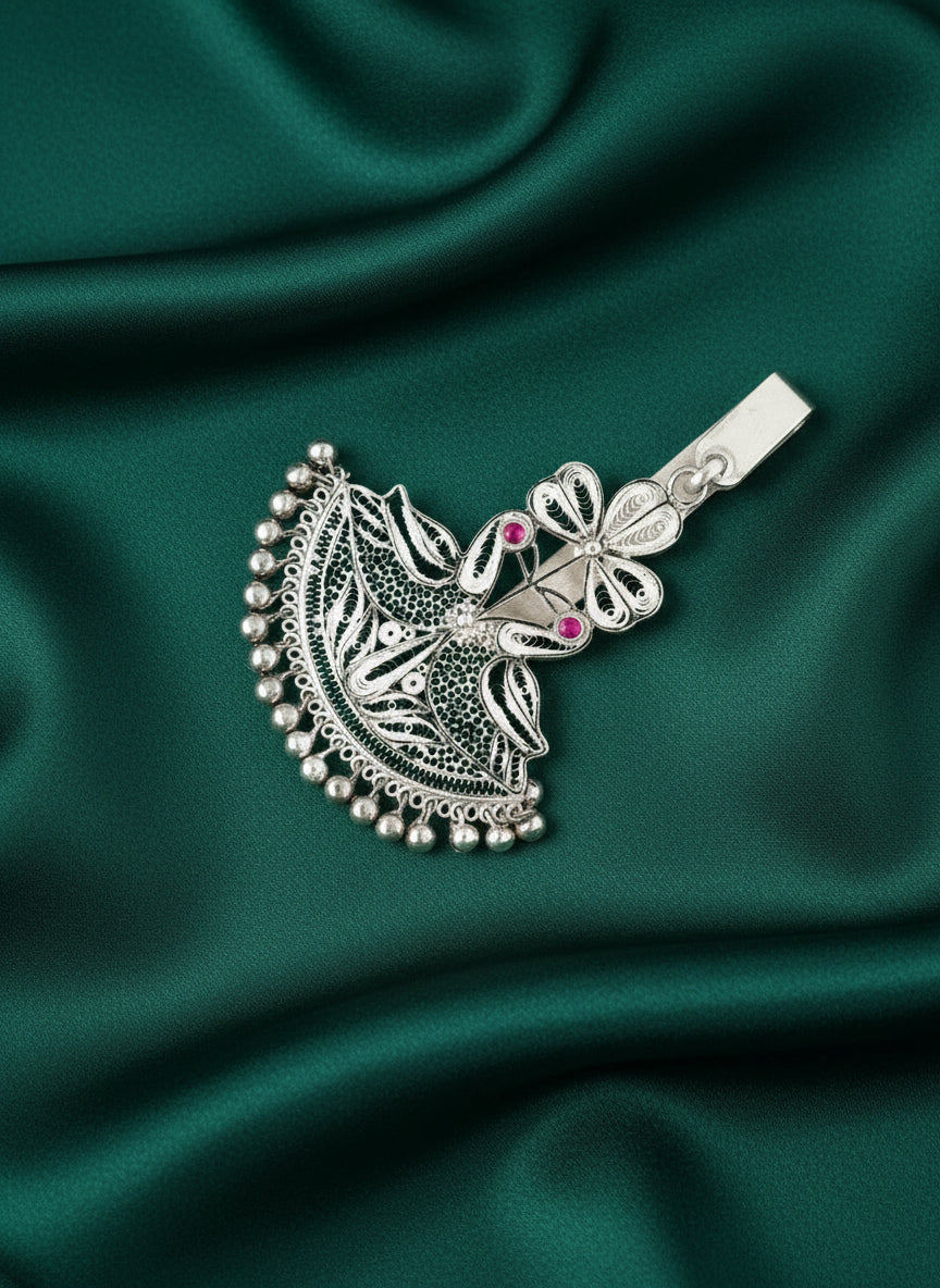 Silver peacock keychain charm close-up with filigree details, pink stones, and clasp