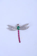 Silver wing brooch for men with green centre stone and pink hanging stone detail.