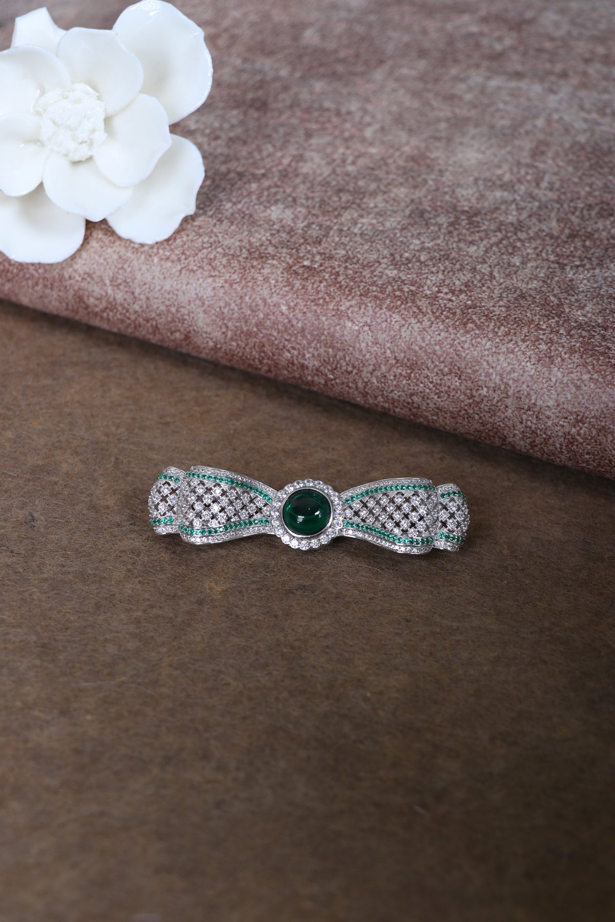 Sterling silver bow brooch with green center stone and pavé accents