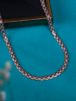 A close-up of a braided silver chain or strap with a repeating geometric pattern in brown, white, and metallic tones, arranged on a bright turquoise background.