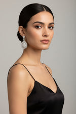 Woman wearing pure silver teardrop earrings with sparkling crystals and an elegant statement design.