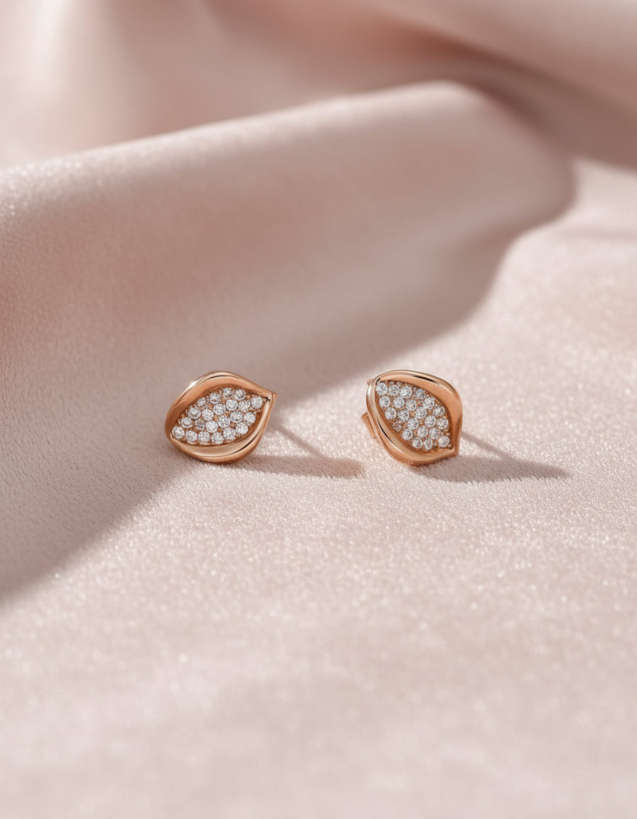 Elegant women’s silver earrings with a curved leaf design and closely set sparkling stones.