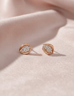 Elegant women’s silver earrings with a curved leaf design and closely set sparkling stones.