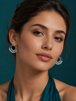 Woman wearing silver hoop drop earrings with layered rings and sparkling crystal embellishments.
