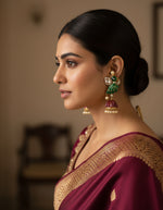 Traditional dangling earrings with green, red, and gold-toned beads and bells
