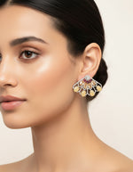 Woman wearing fan-shaped silver earrings with yellow stone drops, red accents and sparkling embellishments.