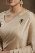Silver brooch with green oval gemstone and sparkling floral crown setting
