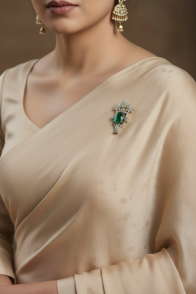 Silver brooch with green oval gemstone and sparkling floral crown setting